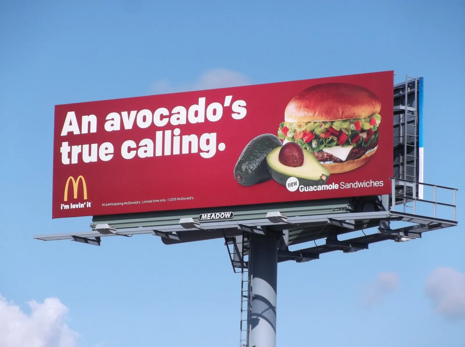 #7. Biển quảng cáo của McDonald's với nền đỏ nổi bật, hình bánh burger kèm quả bơ, cùng slogan: “An avocado’s true calling