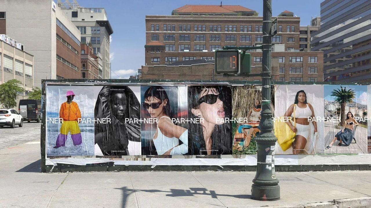 Dãy biển quảng cáo ngoài trời dạng poster dán tường của PAR+NER trải dài trên hàng rào công trình