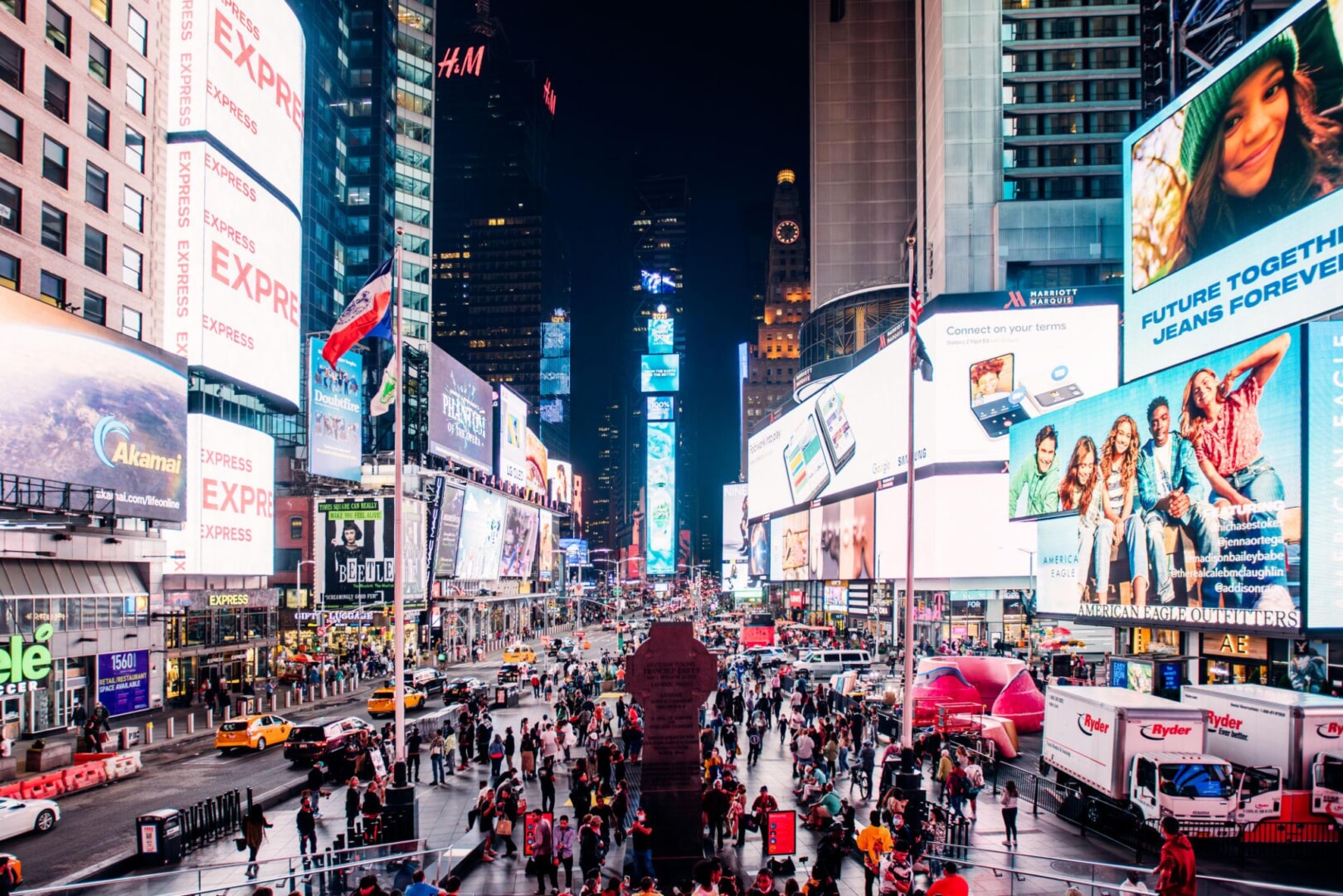 Bức ảnh thể hiện một không gian quảng cáo ngoài trời quy mô lớn (OOH/DOOH) tại khu vực đô thị sầm uất vào ban đêm